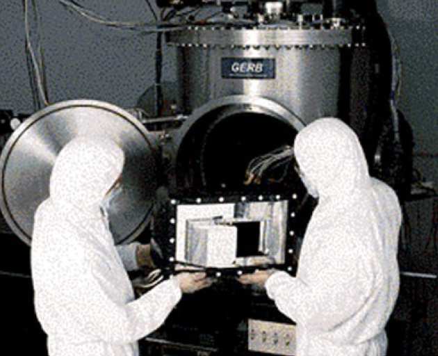 Engineers placing a satellite instrument inside a calibration chamber