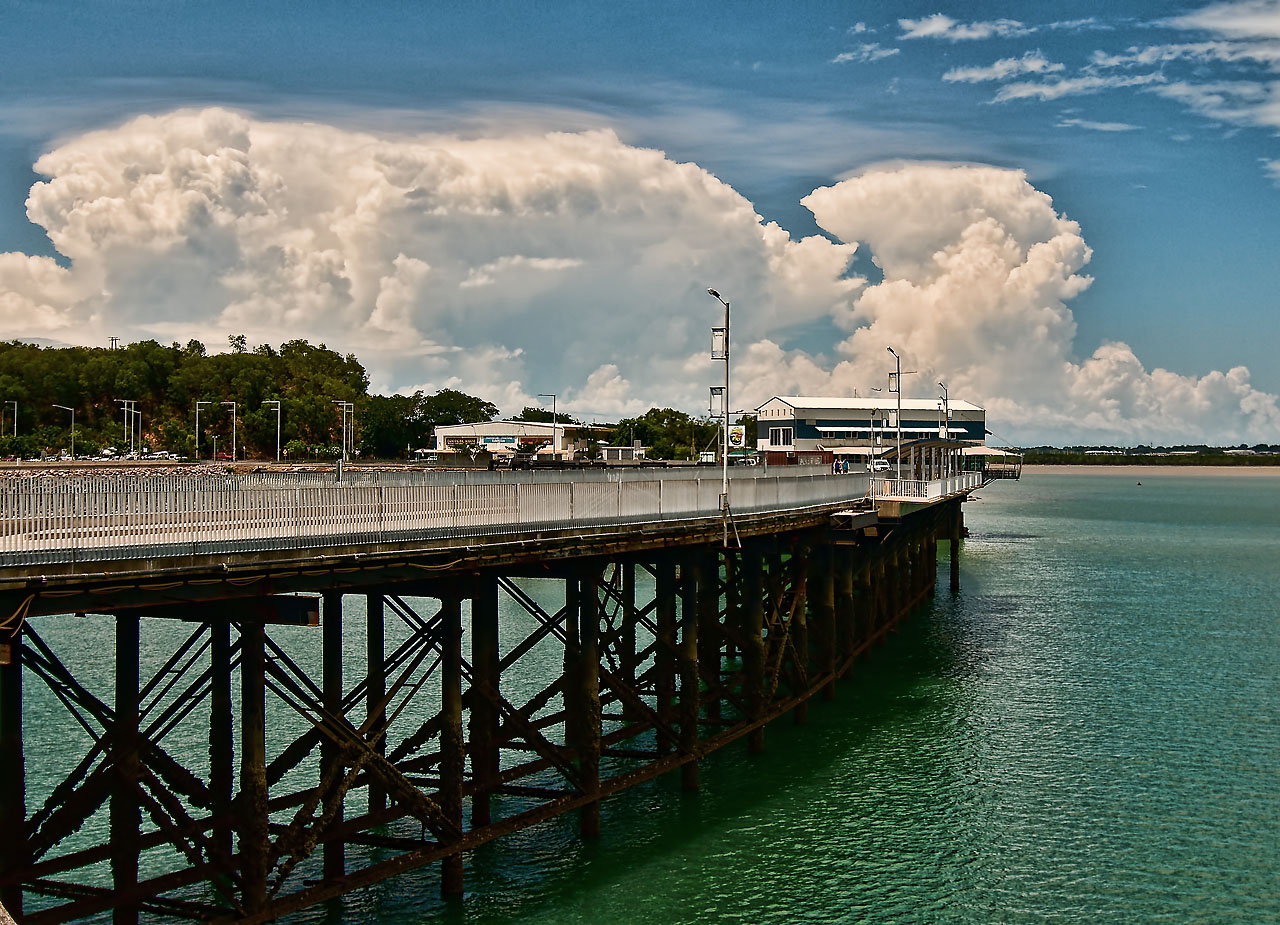 A tropical thunderstorm viewed across a jetty.