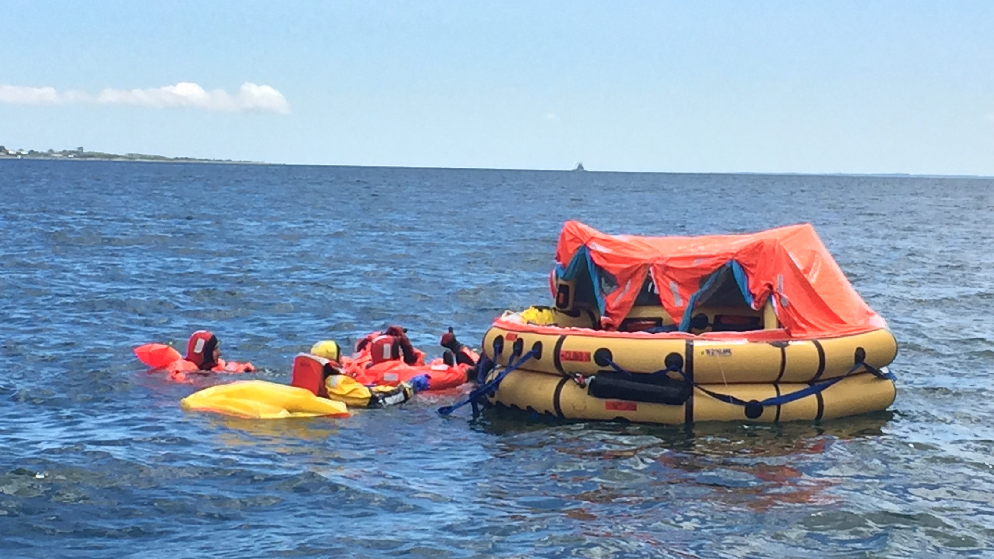 A survival raft near an island with a cloud