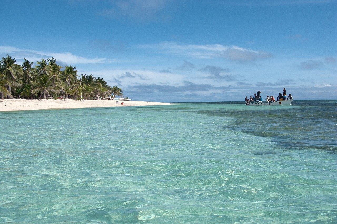 A tropical beach with some clouds in the sky