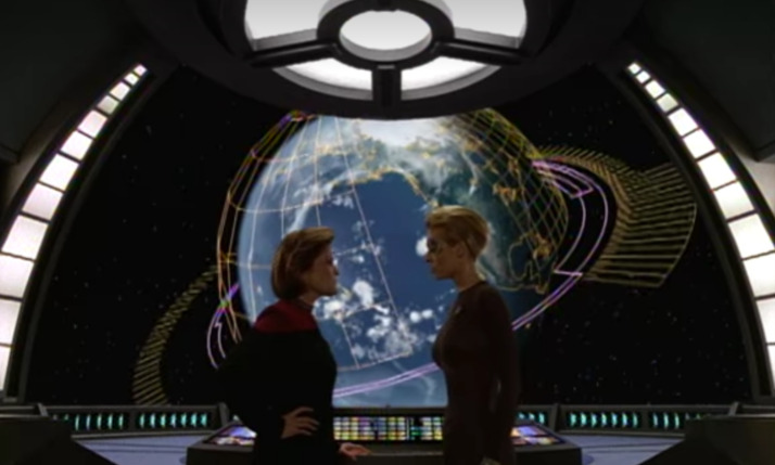 Captain Janeway and Seven of Nine infront of a graphic of Earth