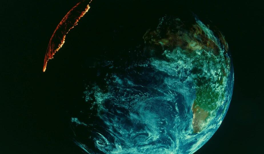 The Earth, partially lit by sunlight. A ring of fire appears over North America.