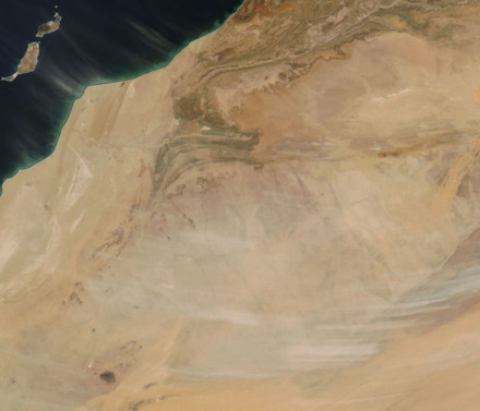 A satellite image of plumes of dust being blown from a desert
